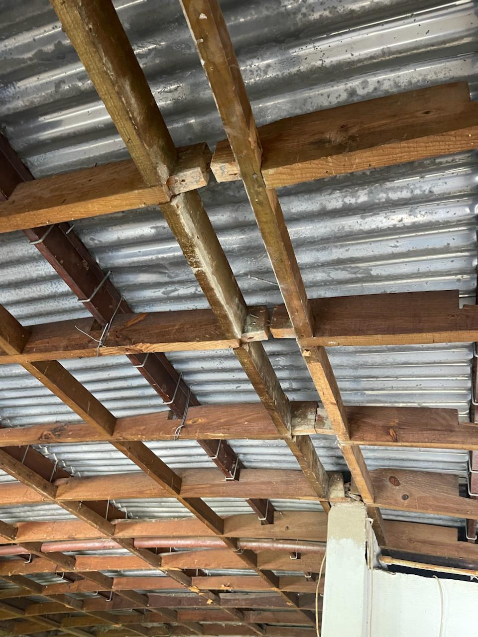 A cobertura, em chapa zincada, exibia um adiantado estado de oxidação e perfurações que deixavam penetrar a luz exterior e causavam infiltrações.